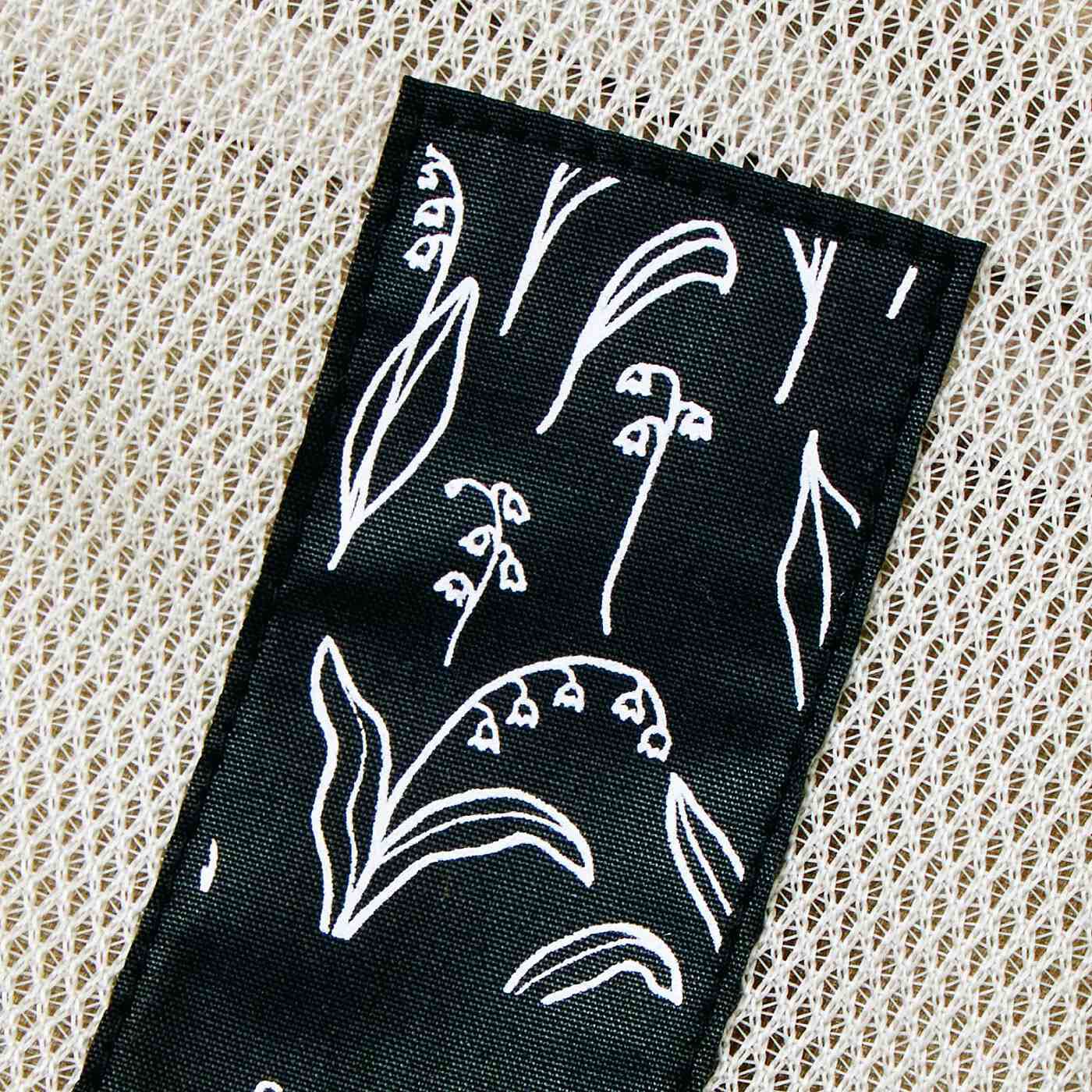 SAANA JA OLLI|サーナ ヤ オッリ　中身が見やすく使いやすく片づく　A4サイズの片面メッシュソフトケース〈モカブラック〉|PATTERN／Lily of The Valley　自由なタッチで描かれたスズラン柄がのびのびとした気分をもたらします。